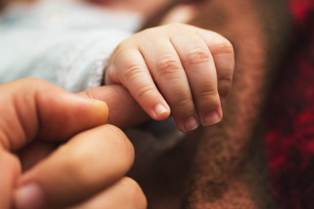 istock New born baby holding his father finger 921294164