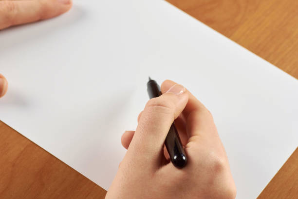 istock Female hands holding calligraphic brush or pen, with white blank paper - with space for text 921297208