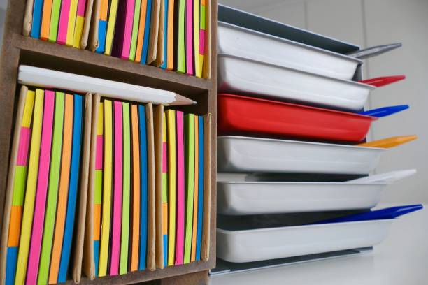 istock Stationery boxes and colorful adhesives notes in a row, on a white table 921297518