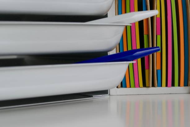 istock Stationery boxes and colorful adhesives notes in a row, on a white table 921301856