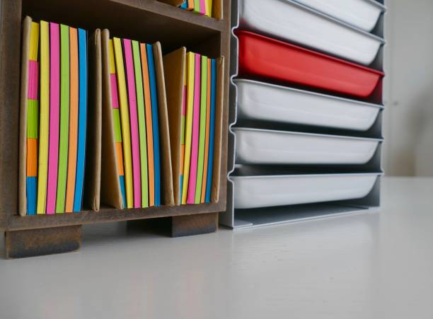 istock Stationery boxes and colorful adhesives notes in a row, on a white table 921302902