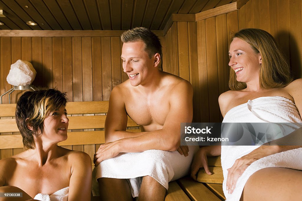 Friends in the sauna Three people (one male, two female) taking a hot sauna, sitting on various benches Human Face Stock Photo