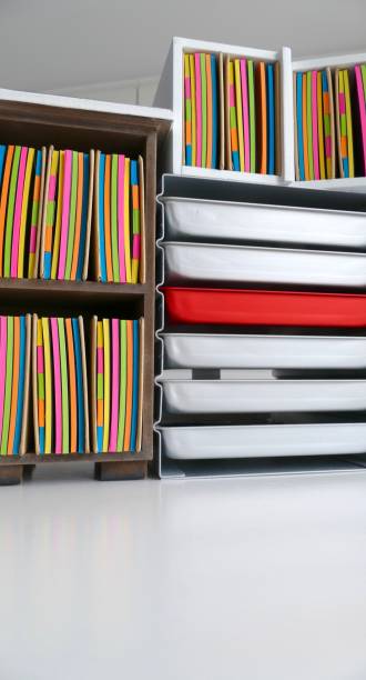 istock Stationery boxes and colorful adhesives notes in a row, on a white table 921305782