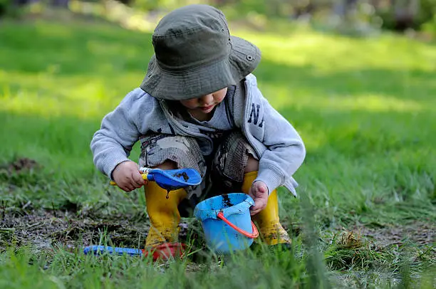 Photo of Young boy plays in the mud