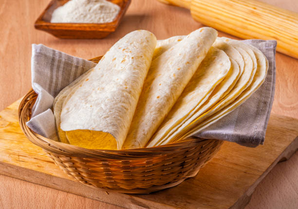 Mexican corn tortillas Homemade Mexican tortillas in a basket with flour and rolling pin. tortilla flatbread stock pictures, royalty-free photos & images