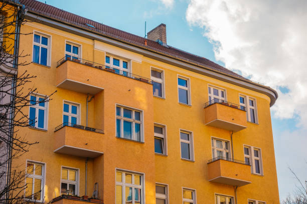 istock orange apartment complex with blue sky and fluffy clouds 921315424