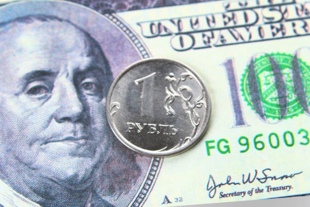 istock coin one ruble against the background US dollars background. 921324336