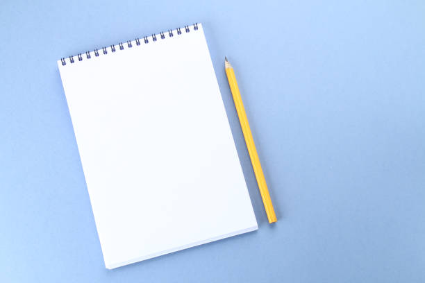 istock Top view image of open notebook with blank pages and coffee on blue background, ready for adding or mock up. Still life, business, office supplies or education concept. 921324372