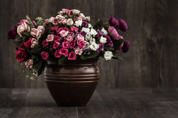 Artificial colorful flowers in a brown flower vase