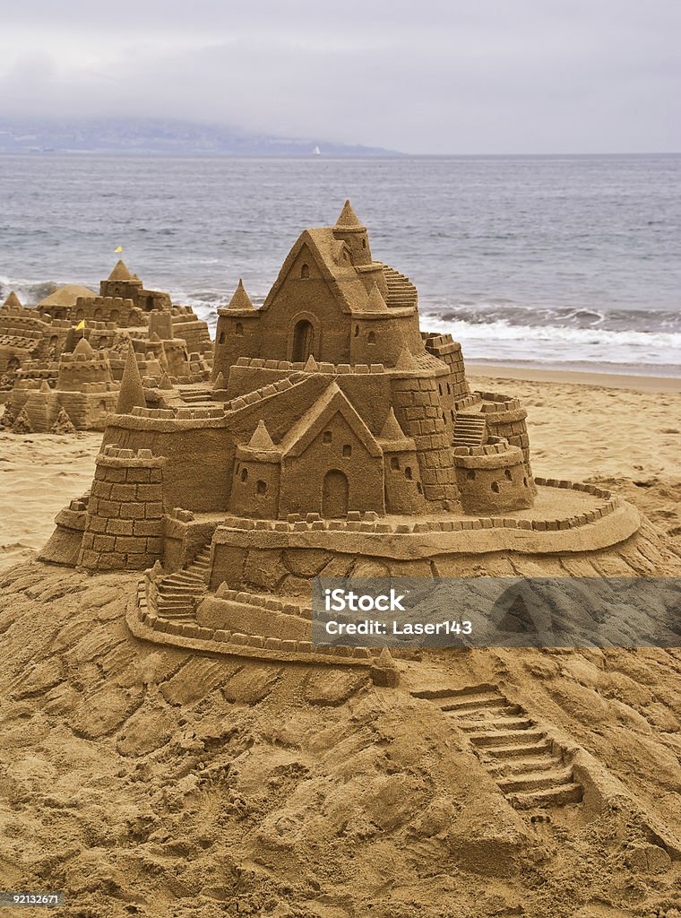 Castillos de arena en la playa, con vista al mar en el fondo. - Foto de stock de Castillo - Estructura de edificio libre de derechos