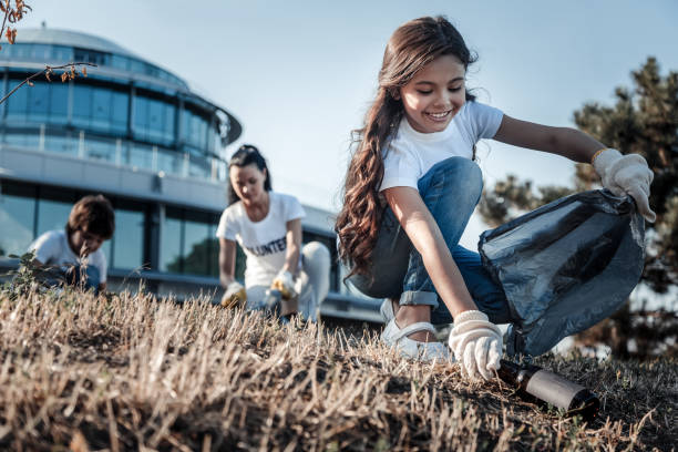 cute cheerful girl picking up a bottle - wasting time imagens e fotografias de stock