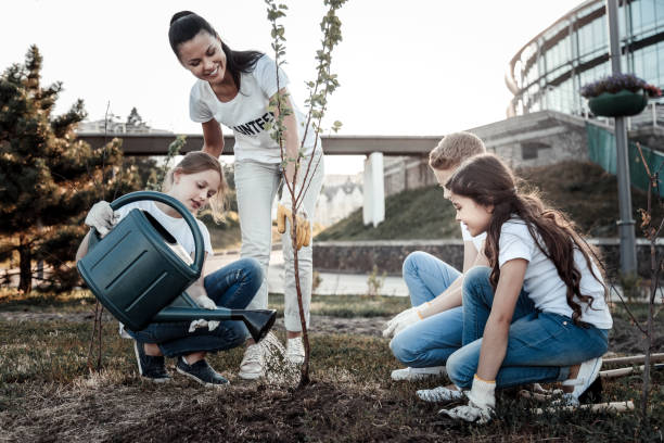 istock Cute young girl watering the tree 921335160