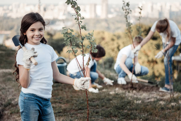 istock Delighted positive girl holing a young tree 921335294