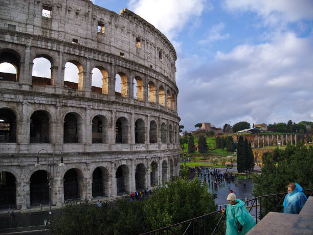 touristen in regenmäntel nahe dem kolosseum in rom, italien - blue rain rome italy stock-fotos und bilder