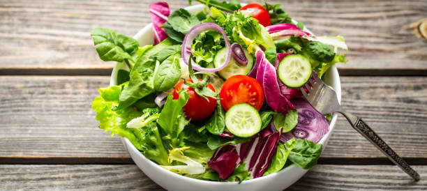 istock Fresh salad on a wooden background 921338540