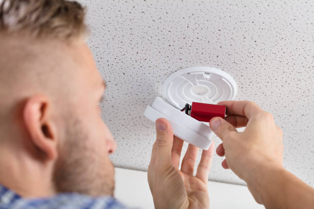 istock Person's Hand Inserting Battery In Smoke Detector 921342358