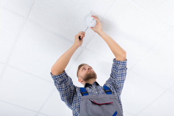 istock Male Electrician Fixing Smoke Detector 921342368