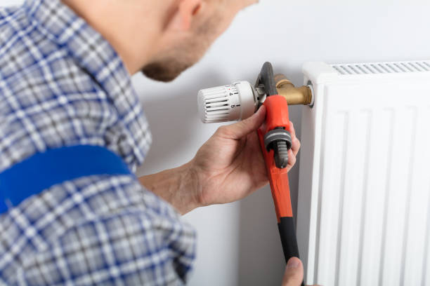 istock Male Plumber Fixing Thermostat Using Wrench 921342406