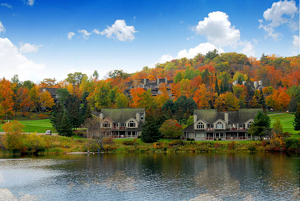 istock Lake side homes in front of autumn trees and a blue sky 92134408