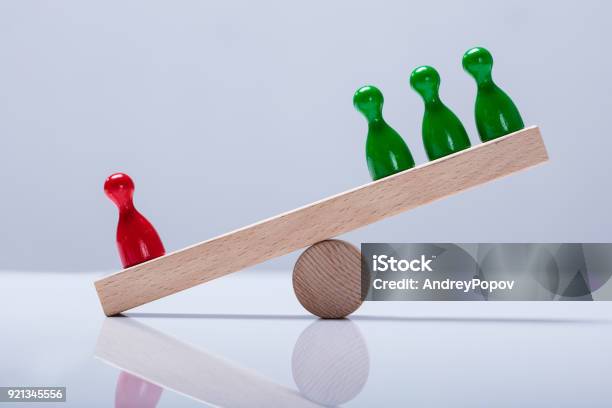 Pawns Figures On Wooden Seesaw Stock Photo - Download Image Now - Imbalance, Seesaw, Balance