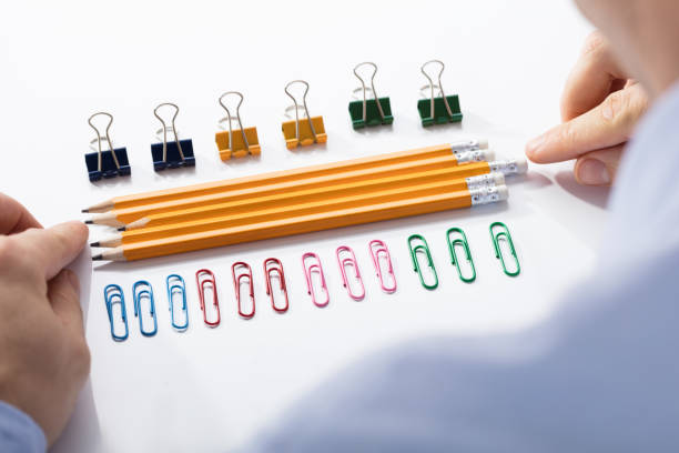 businessman arranging the pencils in between colorful pins - obsessive imagens e fotografias de stock