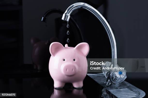 Falling Dripping Water Drop From The Faucet Inside The Piggybank Stock Photo - Download Image Now
