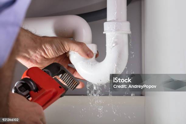 Plumber Fixing Sink Pipe With Adjustable Wrench Stock Photo - Download Image Now - Plumber, Leaking, Repairing