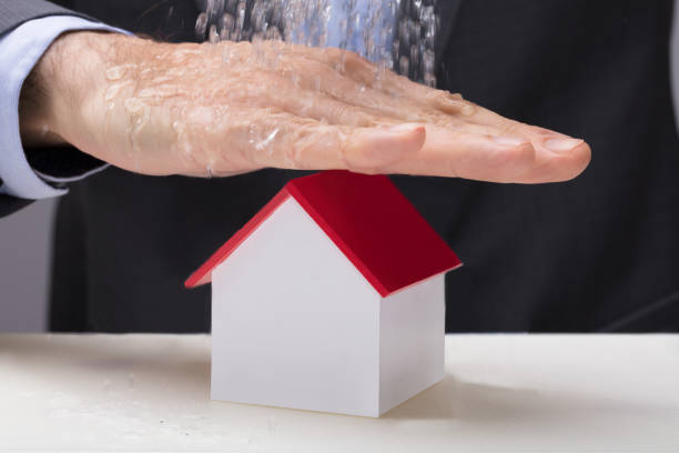 istock Hand Over The House Model From Falling Water 921346106