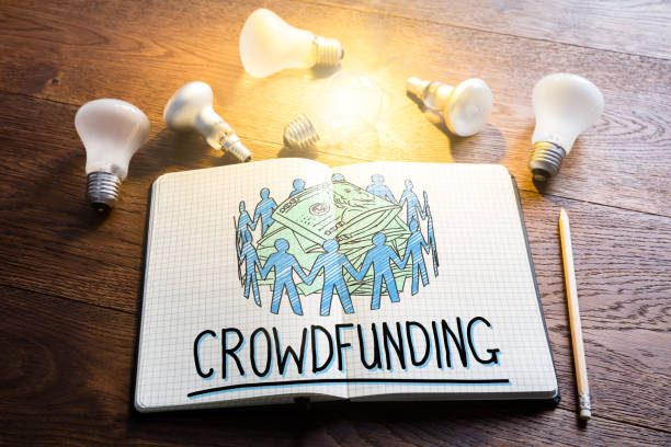 Crowdfunding Concept Crowdfunding Concept In Notepad Near Glowing Lightbulbs crowdfunding stock pictures, royalty-free photos & images