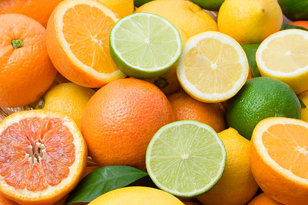 Variety of full and halved citrus fruit stock photo