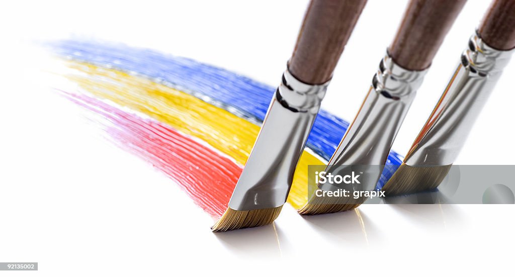 Close-up of three painting brushes drawing different colors three brushes painting colors on white Art Stock Photo