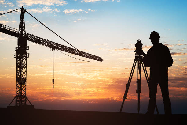 istock Surveyor Standing With Equipment At Construction Site 921352670