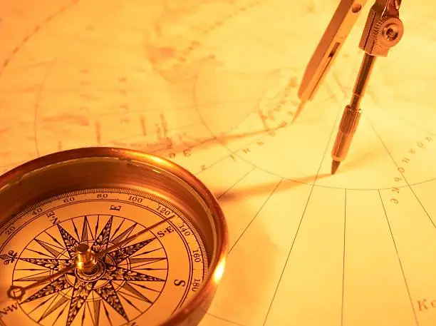 Photo of Golden compass on a map with protractor 