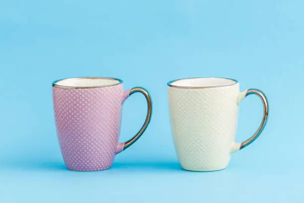 Colorful coffee mugs on blue background