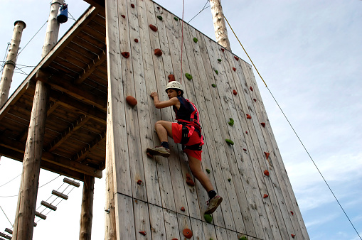 Sport climbing. Climber on the wood climbing wall in Amusement Park.