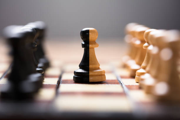 Double Color Pawn Amidst Other Chess Pieces On Board Closeup of double color pawn amidst other chess pieces on board game chess piece photos stock pictures, royalty-free photos & images