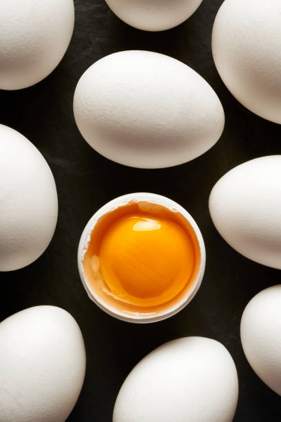 Huevos de gallina con conchas blancas sobre fondo negro - foto de stock