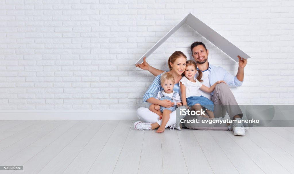 concept housing a young family. mother father and children in  new home concept housing a young family. mother father and children in a new home Family Stock Photo