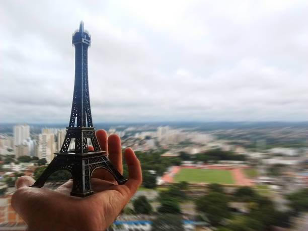 istock Miniature Eiffel Tower in a person's hand against the horizon 921364998