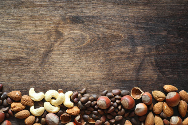 istock Different nuts on a wooden table. Cedar, cashew, hazelnut, walnu 921367256