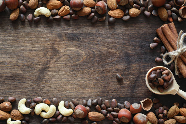 istock Different nuts on a wooden table. Cedar, cashew, hazelnut, walnu 921367356