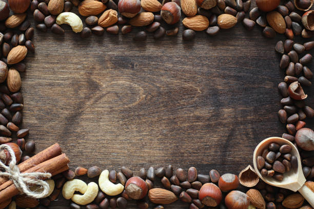istock Different nuts on a wooden table. Cedar, cashew, hazelnut, walnu 921367414