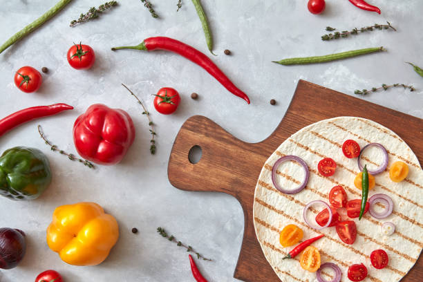 istock Fresh vegetables and tortilla on a wooden board 921368056