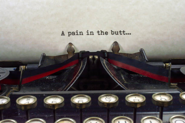 istock Antique typewriter with saying pain in butt 921373942