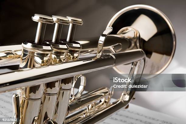 Closeup Of Polished Trumpet Sitting Atop A Sheet Of Music Stock Photo - Download Image Now