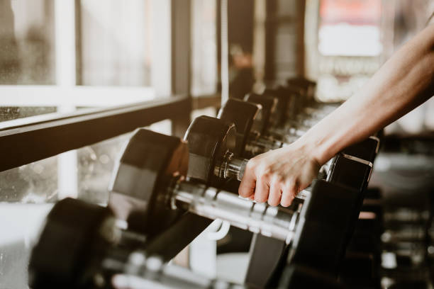 istock hand pick up dumbbell from equipment stand 921407072