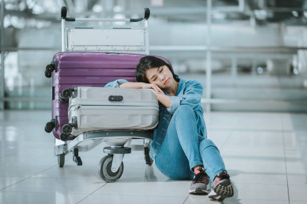 istock Asian woman passenger sleeping with luggage trolley 921411216