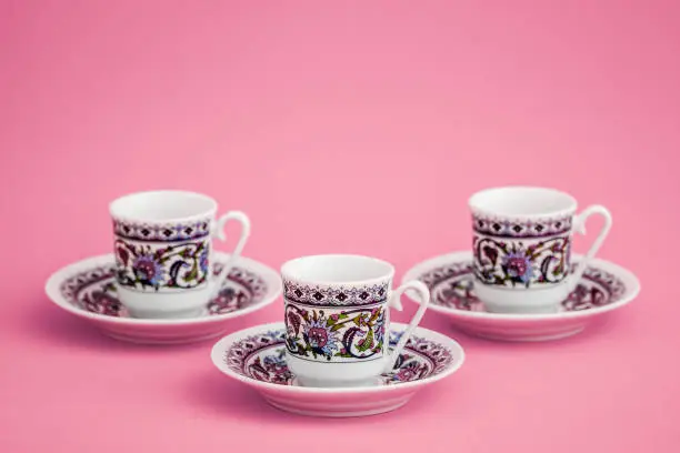 Classic porcelain Turkish coffee cups on pink background