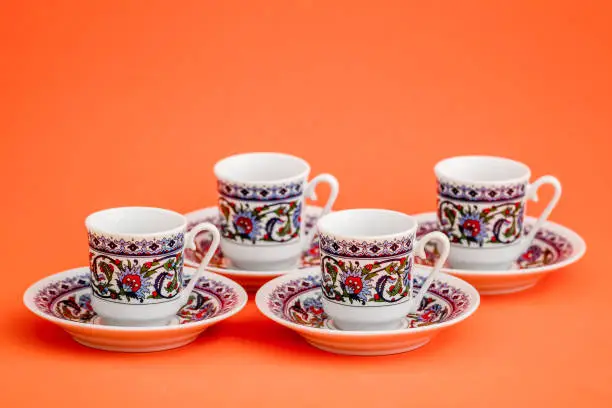 Classic porcelain Turkish coffee cups on orange background