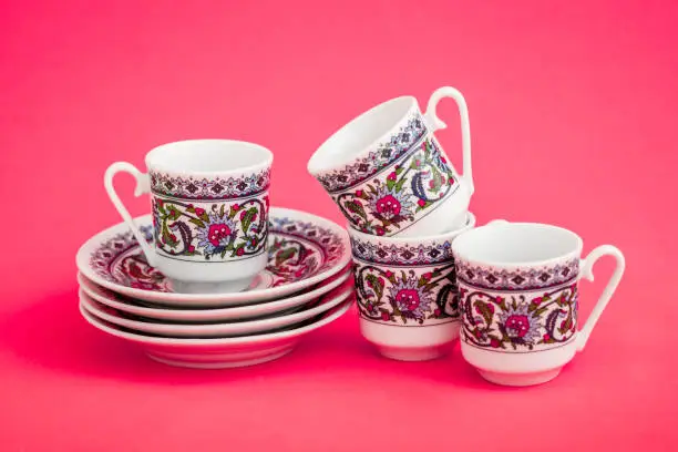 Classic porcelain Turkish coffee cups on pink background background